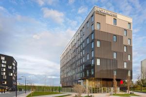 un grand bâtiment avec un panneau sur son côté dans l'établissement Residence Inn by Marriott Paris Charles de Gaulle Central Airport, à Roissy-en-France