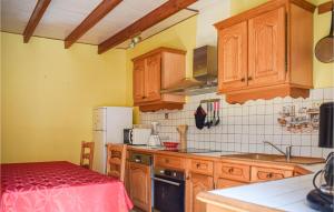 a kitchen with wooden cabinets and a red counter top at Beautiful Home In Lezardrieux With 2 Bedrooms And Wifi in Lézardrieux
