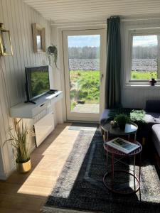 a living room with a couch and a tv at Hytten - Tiny house in Grenå
