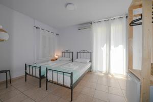 a bedroom with a bed and a table and a window at Hermes Rooms in Tinos