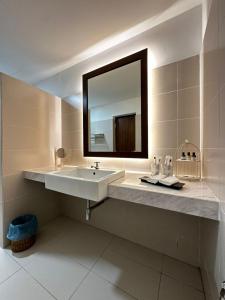 a white bathroom with a sink and a mirror at 19th Century Boutique Hotel in Melaka