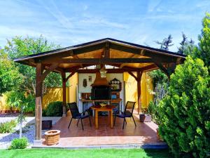 - un pavillon en bois avec des chaises et une table dans un jardin dans l'établissement Villa SIA, à Torrevieja