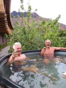 two older men in a hot tub with their cell phones at Casa de Oren in Pisac