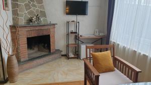 a living room with a fireplace and a television at Lea Guest House in Tbilisi City