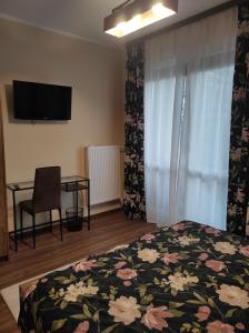 a bedroom with a bed and a table and a television at apartament centrum RP in Katowice