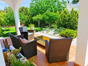 a patio with chairs and a table and a garden at Villa SIA in Torrevieja