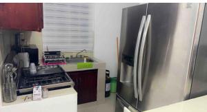 eine Küche mit einem Kühlschrank aus Edelstahl und einer Spüle in der Unterkunft Casa acogedora y familiar in Constanza