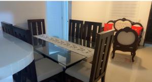 a glass table and two chairs in a room at Casa acogedora y familiar in Constanza