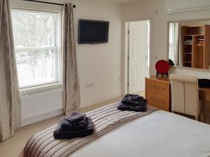 a bedroom with a bed with two black bags on it at The Lodge in Skipwith