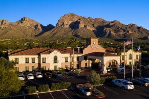 Fairfield Inn & Suites Tucson North/Oro Valley في وادي اورو: مبنى فيه سيارات تقف في موقف فيه جبال