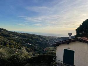 een gebouw met een groene deur bovenop een heuvel bij Ca' Bianca in San Bartolomeo