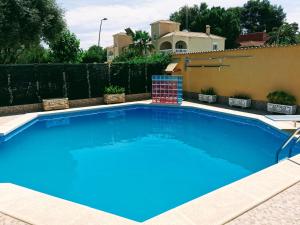 a large blue swimming pool in front of a fence at Villa SIA in Torrevieja