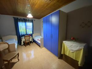 Cette chambre comprend une armoire bleue et 2 lits. dans l'établissement Gather Inn Guest House, à Shkodër