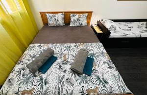 a bedroom with a large bed with a tropical print at The NICE rose - 3 rooms, 3 air cond, 3 TV, 3 fans, WIfi everywhere, Netflix, balcony for smokers, everything is new in Nice