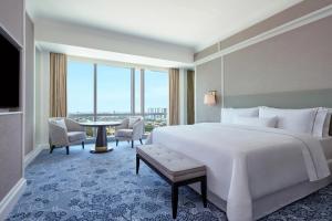 een hotelkamer met een groot bed en een tafel bij The Westin Surabaya in Surabaya