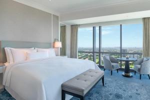 a bedroom with a large bed and a large window at The Westin Surabaya in Surabaya