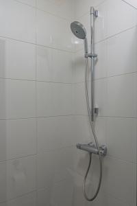 a shower with a shower head in a bathroom at De Witte Meren in Keerbergen