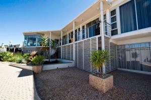 ein Gebäude mit Palmen davor in der Unterkunft Protea Hotel by Marriott Windhoek Furstenhof in Windhoek