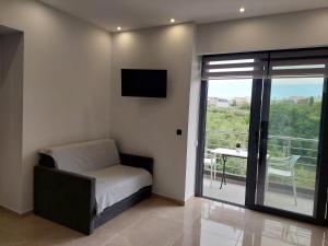 a bedroom with a bed and a tv and a balcony at Luana Monte Apartments in Amoudara Herakliou