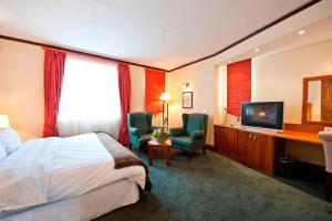 a hotel room with a bed and a television at Protea Hotel by Marriott Windhoek Furstenhof in Windhoek