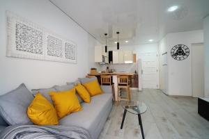 sala de estar con sofá gris y almohadas amarillas en Apartment in central Los Cristianos, en Los Cristianos