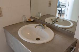 a bathroom with two sinks and a mirror at De Witte Meren in Keerbergen