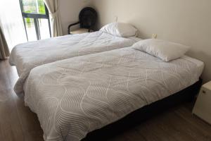 a white bed with two pillows on top of it at De Witte Meren in Keerbergen