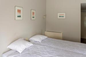 a bedroom with a bed with two pillows on it at De Witte Meren in Keerbergen