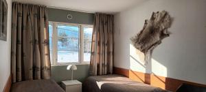 1 dormitorio con 2 camas y ventana en Fishing Lodge Hálsakot, en Sleðbrjótur