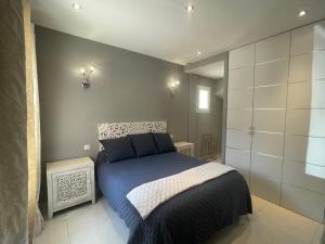 sypialnia z niebieskim łóżkiem w pokoju w obiekcie VILLA PALMIER avec PISCINE CHAUFFÉE PRIVÉE proche D'UZES ET ANDUZE w mieście Cannes-et-Clairan +17 zdjęć