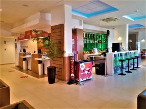 a restaurant with a bar with a drink counter at Ibis Sertaozinho in Sertãozinho