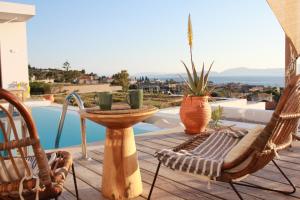 a patio with chairs and a table and a pool at Villa Karma in Paleros