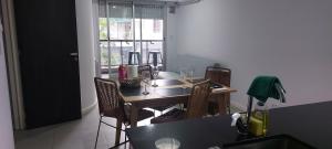 a dining room with a table and chairs and a window at Alquiler Temporario Rosario 10 in Rosario