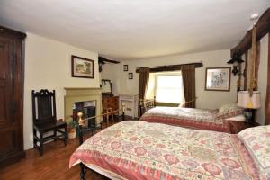 a bedroom with two beds and a fireplace at Pomona in Lowick Green