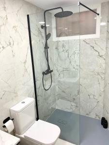 ein Bad mit einem WC und einer Glasdusche in der Unterkunft The Museums Loft - Peña in Málaga