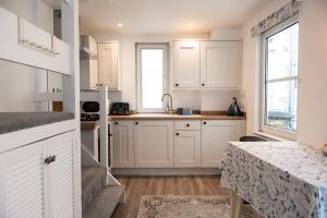 a kitchen with white cabinets and a counter top at Sandals cottage in St Ives