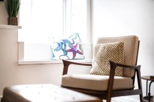 a living room with a chair and a window at Sandals cottage in St Ives