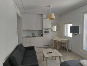 ein Wohnzimmer mit einem Sofa und einem Tisch in der Unterkunft New apparment, near of Airport, in Tikkurila in Vantaa