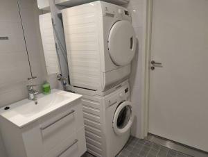 a bathroom with a washing machine and a sink at New apparment, near of Airport, in Tikkurila in Vantaa