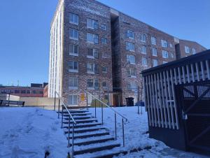 un bâtiment avec des escaliers dans la neige à côté d'un bâtiment dans l'établissement New apparment, near of Airport, in Tikkurila, à Vantaa
