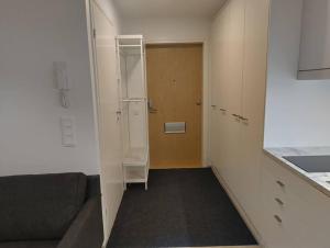 Cette chambre dispose d'un couloir avec un canapé et une porte. dans l'établissement New apparment, near of Airport, in Tikkurila, à Vantaa