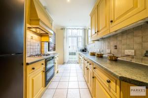 a kitchen with yellow cabinets and a tile floor at The Cromwell Residences in London