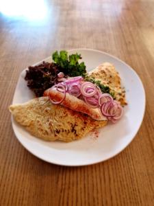 einen Teller Essen mit einem Sandwich mit Zwiebeln drauf in der Unterkunft Gasthof zum Stern in Bad Brückenau