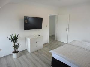 um quarto com uma cama e uma televisão na parede em Ferienwohnung Adrián em Saarbrücken