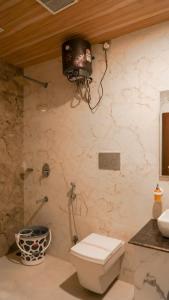 baño con aseo y TV en la pared en Hotel Chulhewala en Jhānsi