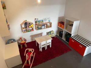 uma cozinha de brinquedo com uma mesa e um frigorífico em Guest House and swimming pool em Romsée