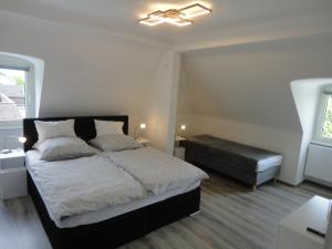 um quarto com uma cama e uma cadeira em Ferienwohnung Adrián em Saarbrücken