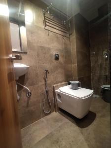 a bathroom with a toilet and a sink at Hotel Kishan Lodging & Boarding in Mumbai