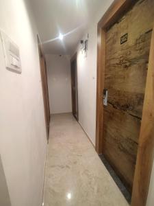 a hallway with a wooden door in a room at Hotel Kishan Lodging & Boarding in Mumbai