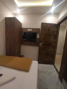 a bedroom with a bed and a door with a tv at Hotel Kishan Lodging & Boarding in Mumbai